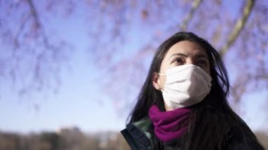 Woman wearing covid-19 face mask walking outside