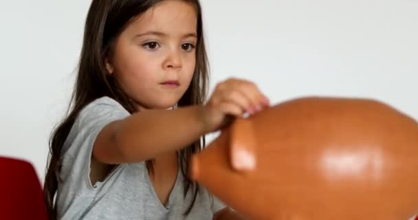 Small Girl Saving Money Adding Coins Piggy Bank — Stock Video