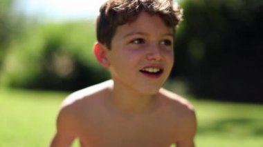 Bahçenin bahçesinde utangaç, çekici, genç bir çocuk.