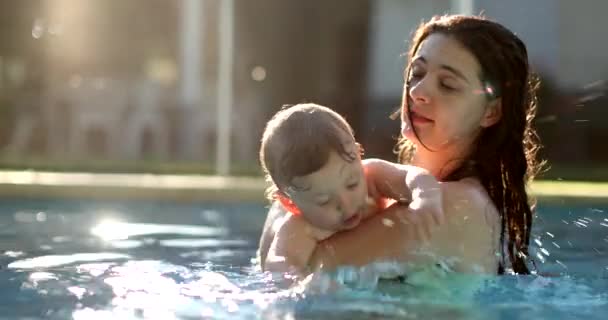 幸せな赤ちゃんがプールで水を撒く — ストック動画