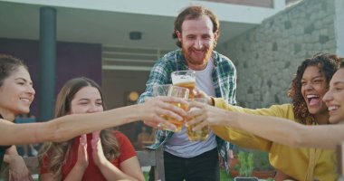 Çeşitli arkadaş grupları kadeh kaldırıyor. İnsanlar açık havada barbekü partisinde kadeh kaldırıyor.