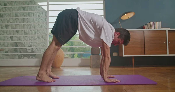Man Stretches Mat Living Room Practices Yoga Does Flexibility Exercises — Zdjęcie stockowe