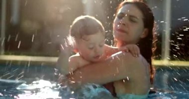 Mother holding baby at the pool