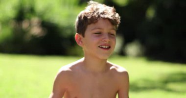 Mutlu yakışıklı çocuk, dışarıda güneş ışığında rahatça oturdu.