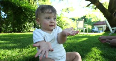 Cute baby gesturing with hand with blank face, Puzzled funny toddler confused
