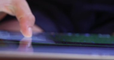 Kid finger touching screen playing game on tablet. Closeup of child hand using device