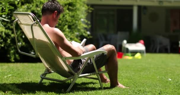 Mężczyzna Czyta Książkę Zewnątrz Domu Podwórku Relaksujący Człowiek Odpoczywa Zewnątrz — Wideo stockowe