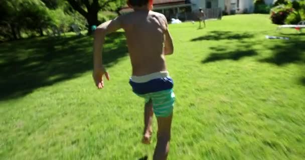 Dziecko Biegnie Zewnątrz Ogrodzie Podwórka Skacze Wody Basenowej — Wideo stockowe
