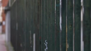Metal bars demarcating property division, security gate on sidewalk urban city