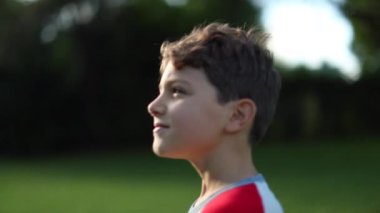 Doğada yürüyen bir çocuk. Düşüncelere dalmış ve meditasyon yapan genç bir çocuk. Çocuk dışarıda düşünüyor.