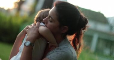 Anne-babası bahçede bebeğini teselli ediyor.