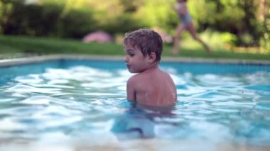 Yüzme havuzundaki çocuğun sırtı soğuktan titriyor.