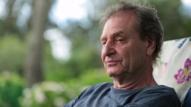 Thoughtful older man outside in contemplation. Pensive contemplative senior man in 70s