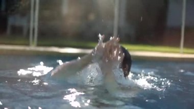 30 'lu yaşlarda neşeli, sıradan bir genç kadın ağır çekimde sudan çıkıyor.