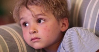 Küçük çocuk gece televizyon izliyor. Akşamları ekrana bakan çocuğun yüzü.