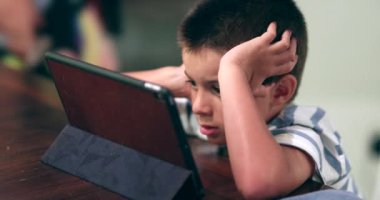 Genç çocuk internetten tablet içeriğini izliyordu. Çocuk film izliyor.