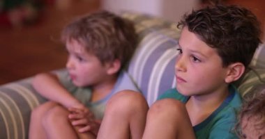 Çocuklar geceleri kanepede televizyon izliyor. Kardeşler gece vakti bir araya gelir.