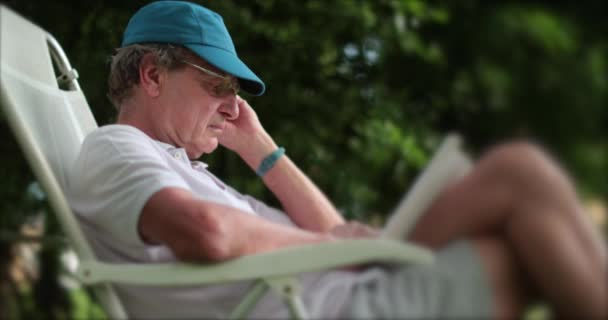 Випадковий Літній Чоловік Читає Книгу Відкритому Повітрі — стокове відео