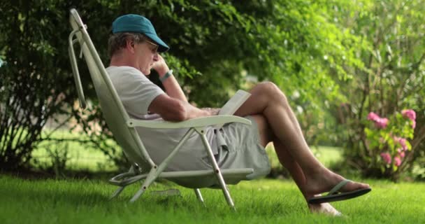 Candid Senior Man Reading Book Daylight Casual Retired Older Man — Stockvideo