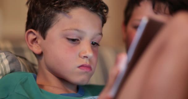 英俊的小男孩晚上用平板电脑 儿童多任务 看电视和玩游戏 — 图库视频影像