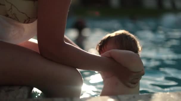 母親と赤ちゃんがプールで一緒に 水泳プールの水で幼児をサポートするお母さん — ストック動画