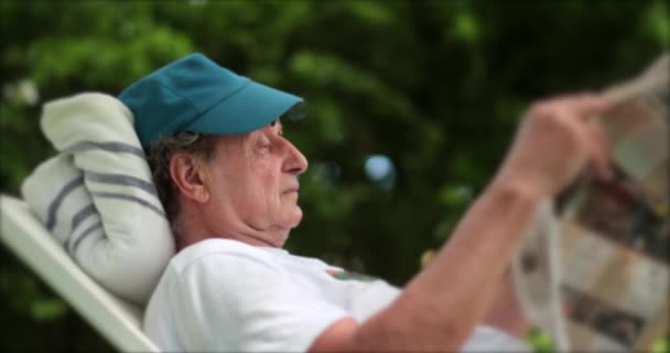 Man Relaxing Outdoors Reading Newspaper Turning Page — Αρχείο Βίντεο