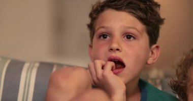 TV 'nin içeriğine kapılmış çocuk. TV izleyen çocuk özümsenmiş