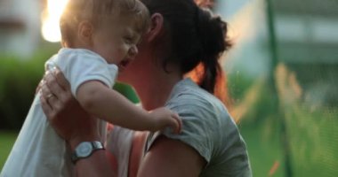 Anne dışarıdaki bebeğe mercekle bakıyor ve onu teselli ediyor.