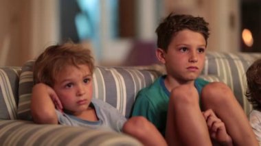 Çocuklar geceleri kanepede televizyon izliyor. Ekranın önündeki çocuklar hipnotize oldu