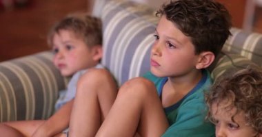 Kanepede oturup gece vakti film seyreden samimi çocuklar.