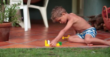 Hayalperest çocuk dışarıda tek başına oynuyor. Çocuk evde oyuncaklarla oynuyor.