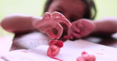 Küçük kız oyun hamuruyla el işi yapıyor. Oynayan ve yaratan çocuk ellerine yakın çekim