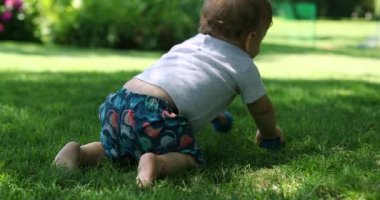 Dışarıda emekleyen sevimli bir bebek. Bebek bebek dışarıda emekliyor.