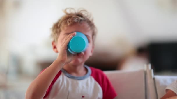子供の男の子はコップで飲料を飲み 次に破裂し 大声でうめき声 — ストック動画