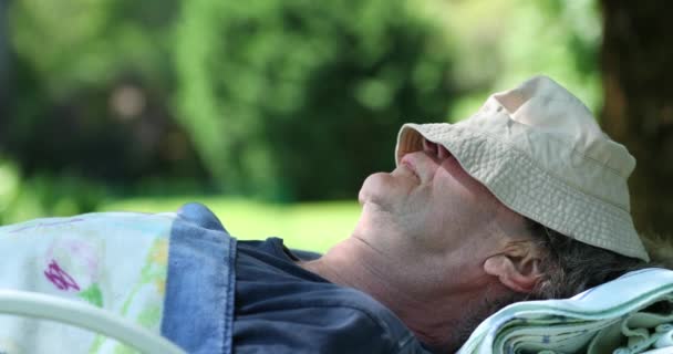 老年人在树下休息 老年人打瞌睡 头戴帽子 — 图库视频影像