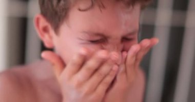 Çocuk kendi yüzüne güneş kremi sürüyor. Çocuk cilde güneş kremi sürer