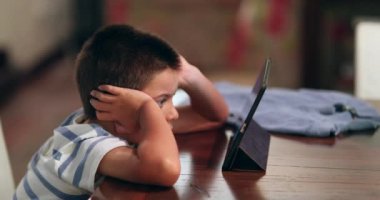 Çocuk tabletten film izliyor. Çocuk teknoloji aygıtından içeriği izliyor