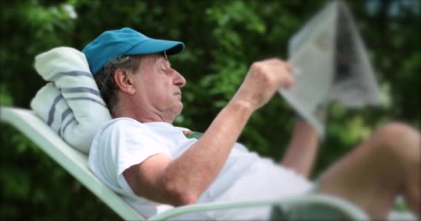 Older Man Reading Newspaper Relaxing Outdoors Laid Backyard — Stockvideo