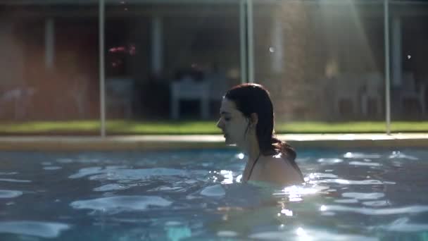 年轻女子在游泳池里把头发往后倾 使自己焕然一新 — 图库视频影像