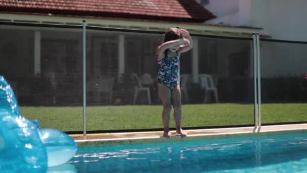 在夏天的一天里 一个活泼的小女孩在游泳池边慢动作地跳入游泳池水 — 图库视频影像