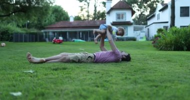 Baba, bebek oğluyla açık hava bahçesinde bağ kuruyor.