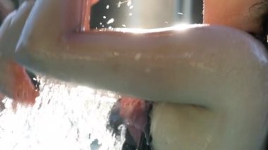 Mother caring and kissing infant toddler child baby at the swimming pool in slow-motion