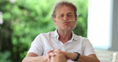 Funny older man grimacing to camera doing fun face