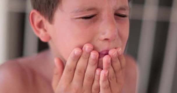 子供の男の子は顔に日焼け止めを広げている 自分自身に日焼け止め化粧水を適用する子供 — ストック動画