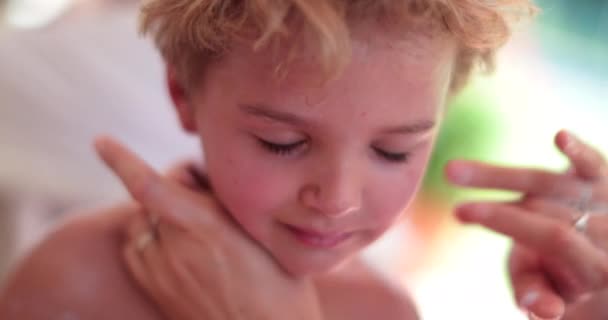 母は子供の顔の予防に日焼け止め化粧水を適用します — ストック動画