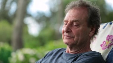 Retired older man relaxing outside. Pensive senior person in outdoor park