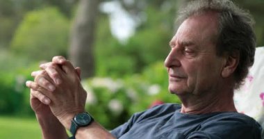 Retired older man relaxing outdoors in contemplation