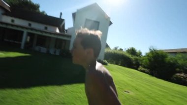 Çocuk koşuyor ve ters takla atıyor. Havuz suyuna sıçrıyor.