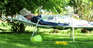 Senior man sleeping outside. Older man resting and napping outdoors