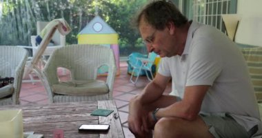 Senior man using cellphone device at home, casual and candid